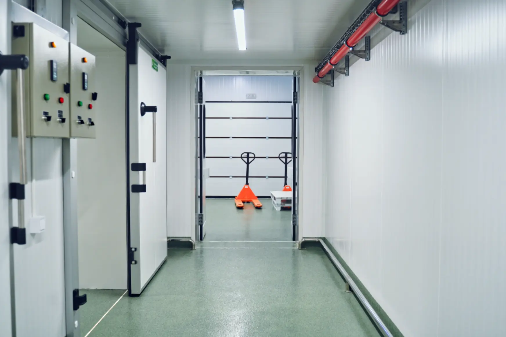Chiller room corridor with multiple access doors, control panel and material handling equipment in an Abu Dhabi facility