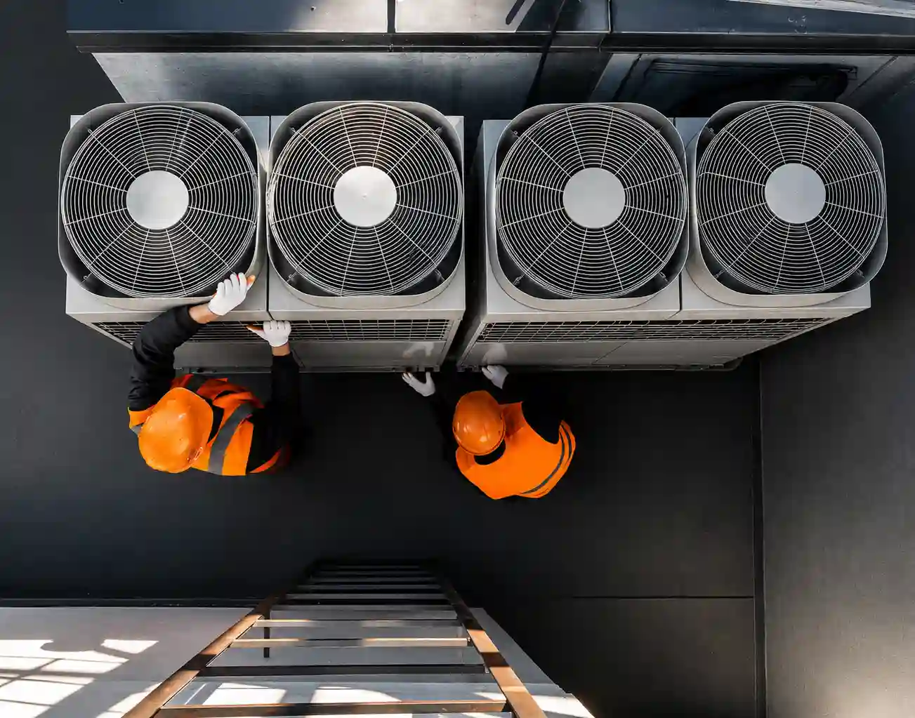 Technicians installing refrigeration units for a blast chiller room in UAE with industrial condenser fans and cooling equipment